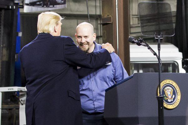 President Donald Trump celebrates with Ken Wilson, an employee of H&K Equipment, at H&K Equipment in Coraopolis, Penn., on Jan. 18, 2018. (Charlotte Cuthbertson/The Epoch Times)