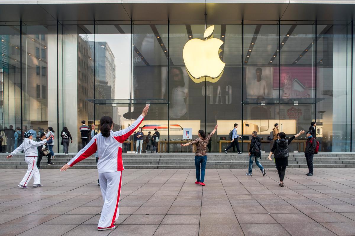 Elderly people perform square dance in front of an Apple store in Shanghai, China, on nov. 3, 2017. Apple is relinquishing control over its iCloud servers for Chinese users to a Chinese state-owned company in China, citing compliance with Chinese regime laws. (VCG via Getty Images)
