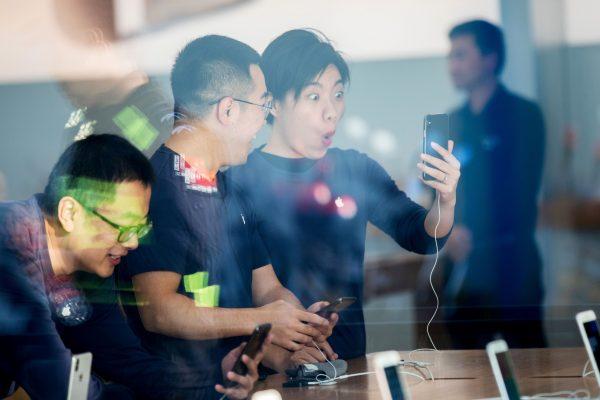 Staff look at the new iPhone X at the Apple store in Hangzhou in China's eastern Zhejiang province on Nov. 3, 2017. Apple is relinquishing control over its iCloud servers for Chinese users to a Chinese state-owned company in China, citing compliance with Chinese laws.(STR/AFP/Getty Images)