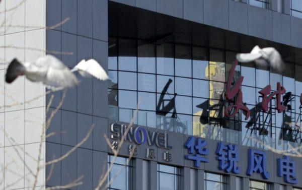 Pigeons fly past the company logo of Sinovel Wind Co., Ltd. outside its head office in Beijing, on January 6, 2011. (Soo Hoo Zheyang/Reuters)