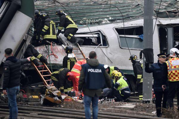 Fire fighters and police officers work around derailed trains in Pioltello, on the outskirts of Milan, Italy, Jan. 25, 2018. (Reuters/Stringer)