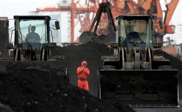 An employee walks between front-end loaders which are used to move coal imported from North Korea at Dandong port in the Chinese border city of Dandong, Liaoning province Dec. 7, 2010. (Reuters/Stringer/File Photo)