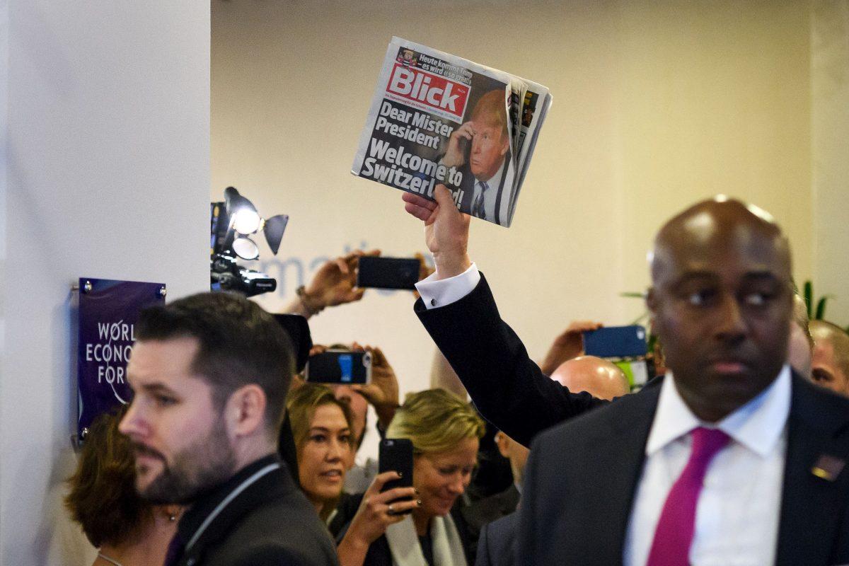President Trump holds up the Swiss newspaper Blick, as he arrives at the WEF in Davos, on Jan. 26, 2018. (FABRICE COFFRINI/AFP/Getty Images)
