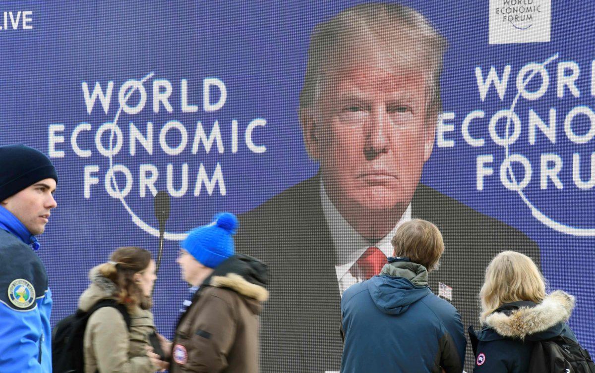 People watch a screen broadcasting President Trump’s speech at the WEF in Davos, on Jan. 26, 2018. (MIGUEL MEDINA/AFP/Getty Images)