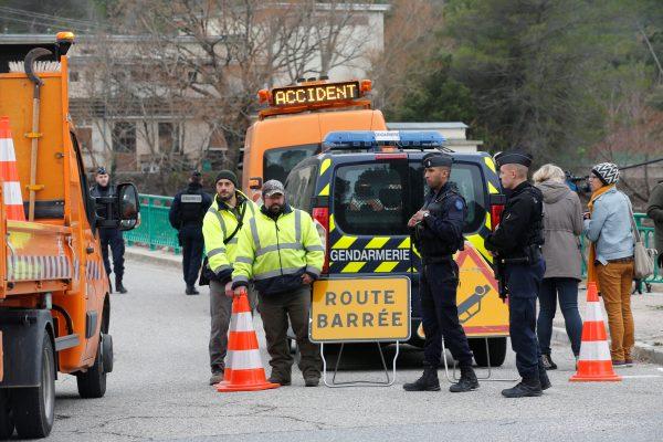 Gendarmes block the road near the site where two French military helicopters belonging to an army flight training school crashed killing five people near the Lac de Carces in the southeastern Var region, France, Feb. 2, 2018. (Reuters/Jean-Paul Pelissier)