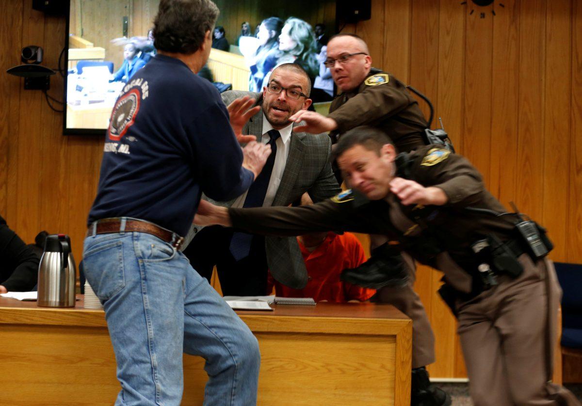 Randall Margraves (L) lunges at Larry Nassar (wearing orange) in the Eaton County Circuit Court, Feb. 2, 2018. (Reuters/Rebecca Cook)