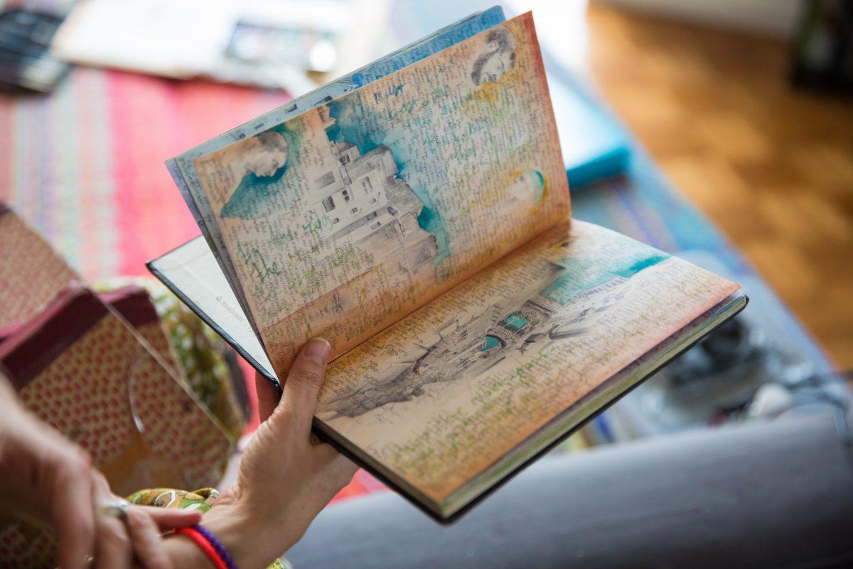 Dina Brodsky holds one of her sketchbooks, at her home on Jan. 22, 2018. (Benjamin Chasteen/The Epoch Times)