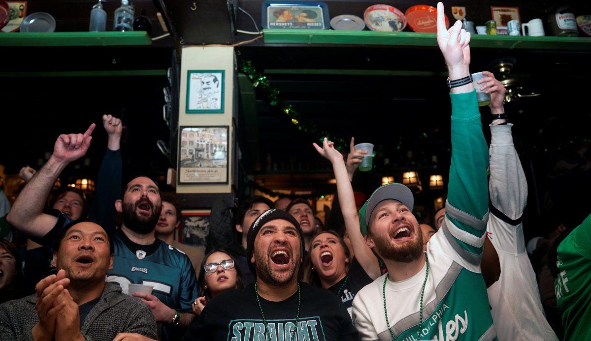 Football fans react as they watch Super Bowl LII between the New England Patriots and the Philadelphia Eagles at the city's oldest tavern, McGillin's Olde Ale House in Philadelphia, Pennsylvania on Feb. 4, 2018. (Reuters/Jessica Kourkounis)