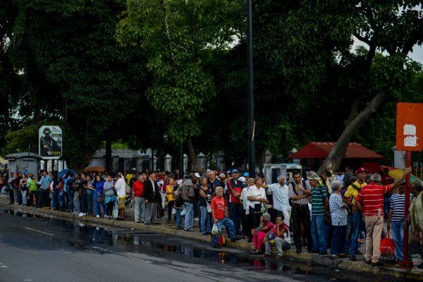 People queue at a bus stop in Catia, a neighbourhood of Caracas, on Nov. 1, 2017. People queue for upto four hours to take a bus home in Venezuela, where mobilizing by land or plane has become a headache. (FEDERICO PARRA/AFP/Getty Images)