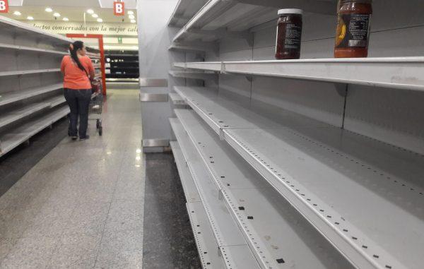 A woman walks between the empty shelves of a supermarket in Caracas on Jan. 11, 2018. Colombian President Juan Manuel Santos, on Thursday called his Venezuelan counterpart Nicolas Maduro to accept international aid to help Venezuelan people to stop "suffering hunger and lack of medicines." (JUAN BARRETO/AFP/Getty Images)