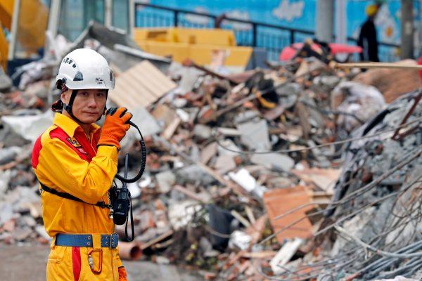 A rescuer speaks on the radio as he searches for survivors at collapsed building after an earthquake hit Hualien, Taiwan on Feb. 8, 2018. (Reuters/Tyrone Siu)