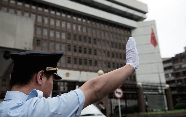 A policeman gestures in front of the Shanghai Intermediate Court on August 8, 2014. (Johannes Eisele/AFP/Getty Images)