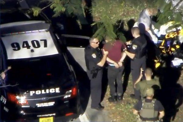 A man placed in handcuffs is led by police near Marjory Stoneman Douglas High School following a shooting incident in a still image from video in Parkland, Florida, on Feb. 14, 2018. (<a href="http://WSVN.com" target="_blank" rel="noopener noreferrer">WSVN.com</a> via Reuters)