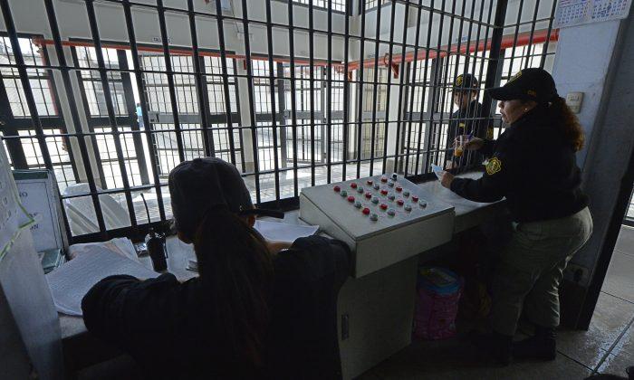 Female prison guards in a security cage monitor the doors between areas allowing movement of personnel, visitors. and inmates at the Ancon 2 prison, part of the Piedras Gordas Model Penitentiary complex, Peru. (Cris Bouroncle/AFP/Getty Images)