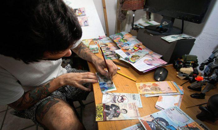 Jose Leon, 26, paints on devalued bolivar bills. (George Castellanos/AFP/Getty Images)