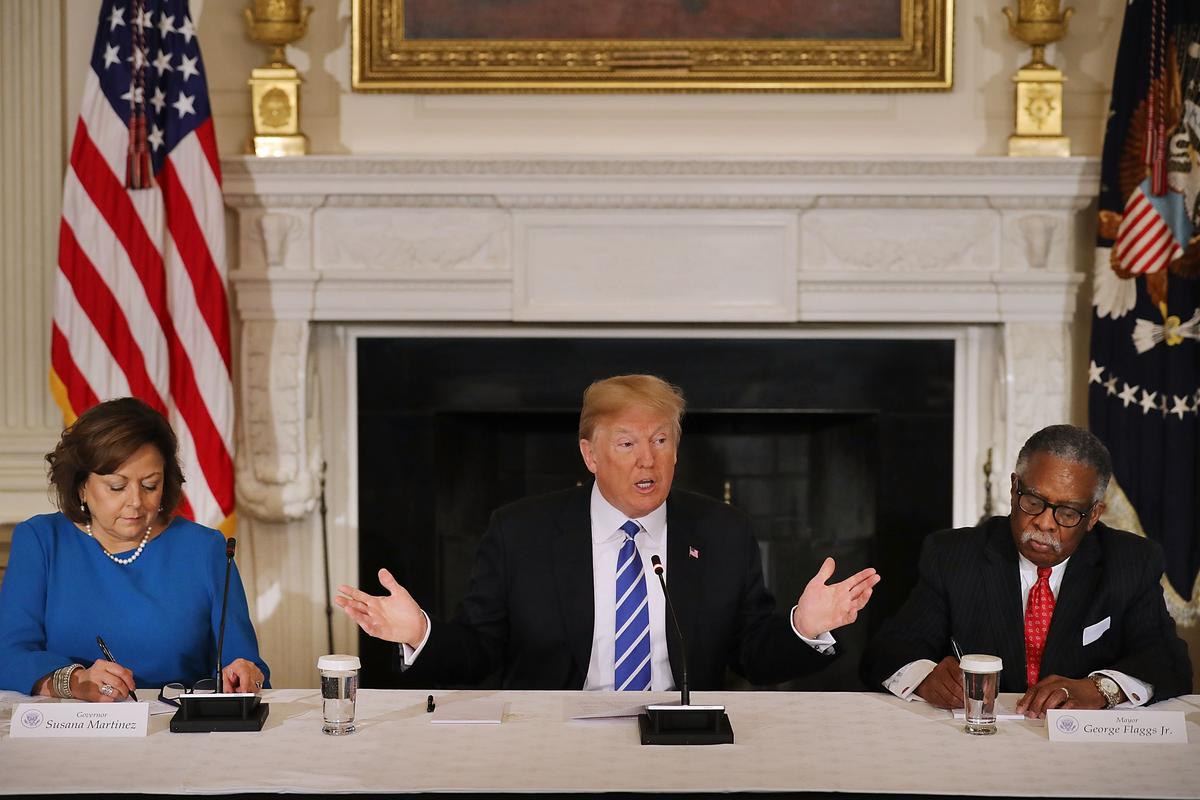 President Donald Trump (C) is flanked by New Mexico Gov. Susana Martinez (L) and Vicksburg, Mississippi, Mayor George Flaggs Jr. during a meeting with state and local officials to unveil his administration's long-awaited infrastructure plan in the State Dining Room at the White House in Washington on Feb. 12, 2018. The $1.5 trillion plan to repair and rebuild the nation's crumbling highways, bridges, railroads, airports, seaports and water systems is funded with $200 million in federal money with the remaining 80 percent coming from state and local governments. (Chip Somodevilla/Getty Images)