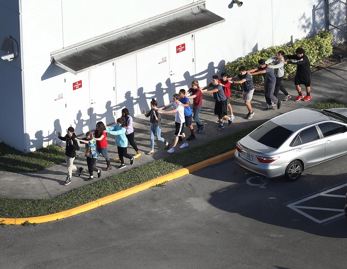 People are brought out of the Marjory Stoneman Douglas High School after a shooting at the school that left 17 people dead February 14, 2018 in Parkland, Florida. (Photo by Joe Raedle/Getty Images)