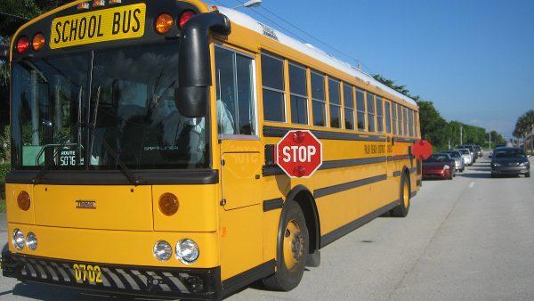 A school bus stops, preparing to unload students. (commons.wikimedia.org)