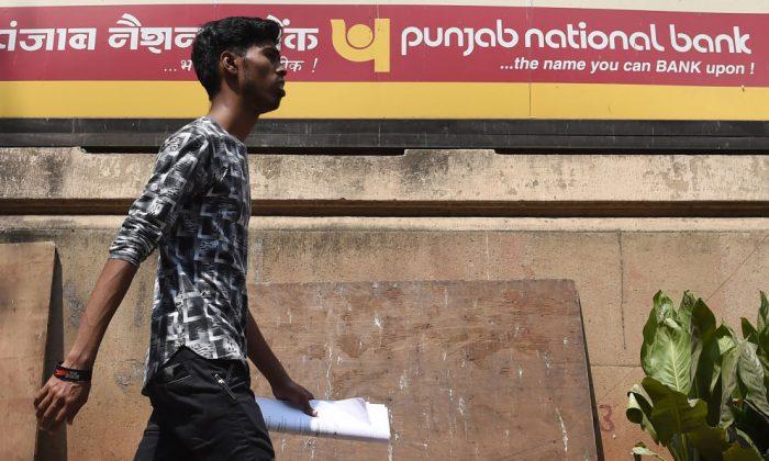 An Indian man walks past a sign for the state-owned Punjab National Bank (PNB) in Mumbai on February 14, 2018. (Indranil Mukherjee/AFP/Getty Images)