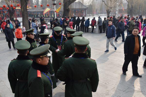 Chinese paramilitary police officers watch over a crowd at a Lunar New Year temple fair in Beijing on Feb. 19, 2018. (Greg Baker/AFP/Getty Images)