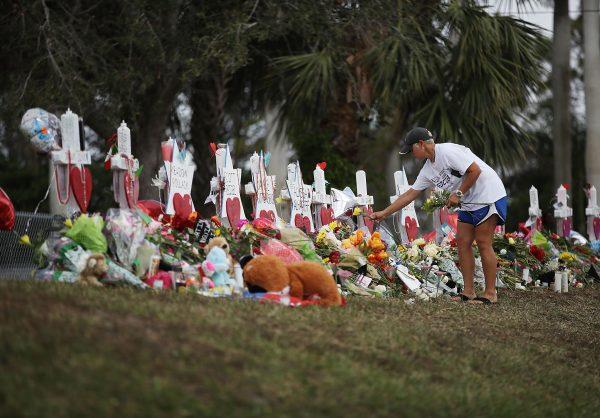 Melissa Shev visits a makeshift memorial set up in front of Marjory Stoneman Douglas High School in memory of the 17 people that were killed on Feb. 14, in Parkland, Florida on Feb. 20, 2018. (Joe Raedle/Getty Images)