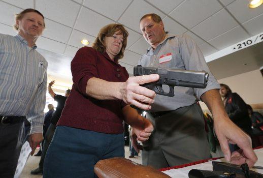 A Utah teacher is shown how to handle a handgun by instructor Clint Simon (R), at a concealed-weapons training class to 200 Utah teachers in West Valley City, Utah, on Dec. 27, 2012. (George Frey/Getty Images)