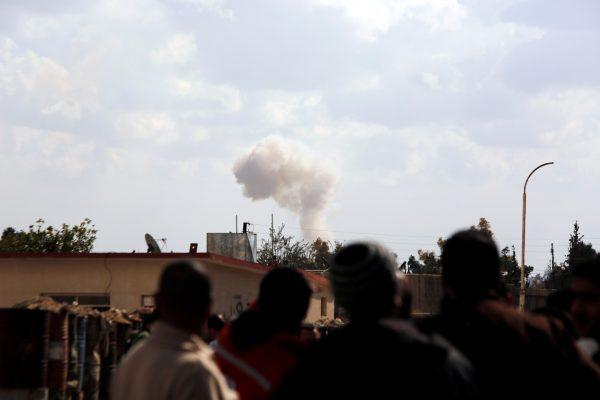 People watch as smoke rises in eastern Ghouta, Damascus, Syria Feb. 28, 2018. (Reuters/Omar Sanadiki)