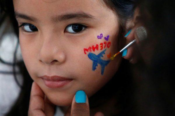 A girl gets her face painted during the fourth annual remembrance event for the missing Malaysia Airlines flight MH370, in Kuala Lumpur, Malaysia March 3, 2018. (Reuters/Lai Seng Sin)