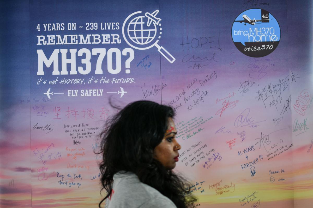 A woman walks past a banner bearing solidarity messages for passengers of the missing Malaysia Airlines flight MH370, during a memorial event in Kuala Lumpur on March 3, 2018 ahead of the fourth anniversary of at the ill-fated planes disappearance. (Manan Vatsyayana/AFP/Getty Images)