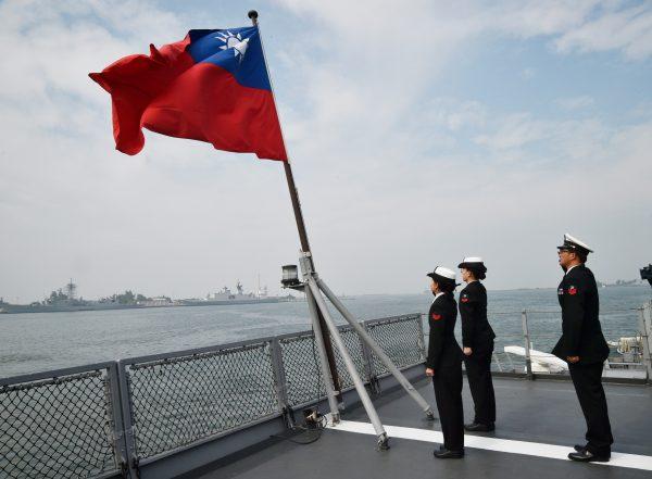 Taiwanese sailors salute the nation’s flag on the deck of the Panshih supply ship at the Tsoying naval base in Kaohsiung on Jan. 31, 2018.  (Mandy Cheng/AFP/Getty Images)