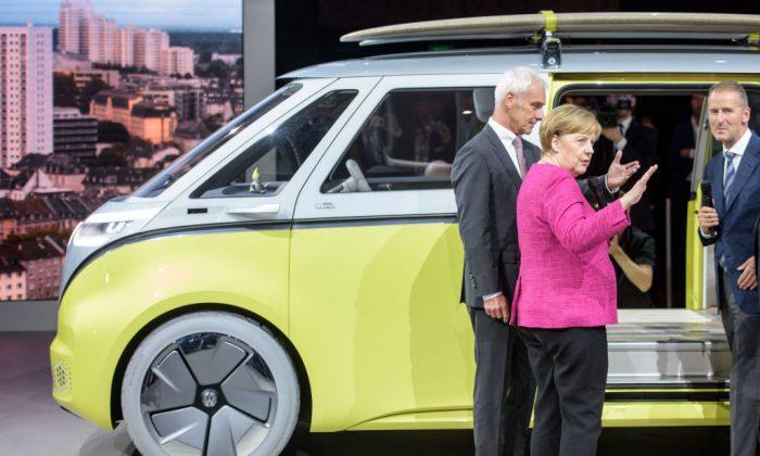 The CEO of Volkswagen Matthias Mueller (L) and Volkwagen executive Herbert Diess (R) speak with the German Chancellor Angela Merkel next to a VW iQ Buzz concept car at the Frankfurt Auto Show on September 14, 2017. (Thomas Lohnes/Getty Images)