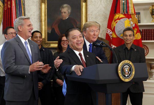 U.S. President Donald Trump hugs Broadcom CEO Hock Tan as Tan announces the repatriation of his company's headquarters to the United States from Singapore during a ceremony in the Oval Office of the White House in Washington, DC on November 2, 2017. (Martin H. Simon/Pool/Getty Images)
