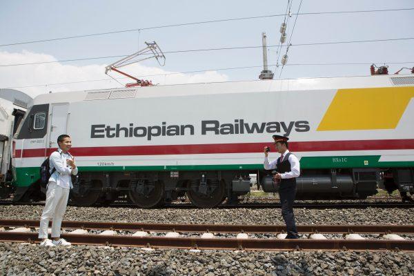 Chinese employees of the new railway which will link Addis Ababa to Djibouti take pictures in front of the Chinese-made Ethiopian trains in Addis Ababa on September 24, 2016. (Zacharias Abubeker/AFP/Getty Images)