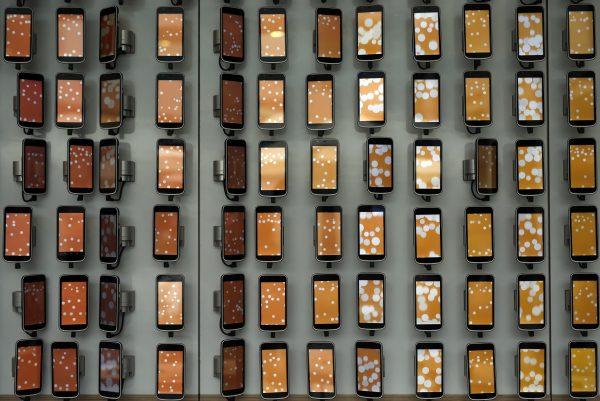 Smartphones hang on a wall at the Mobile World Congress (MWC), the world's biggest mobile fair, in Barcelona, Spain, on February 28, 2018. (Pau Barrena/AFP/Getty Images)