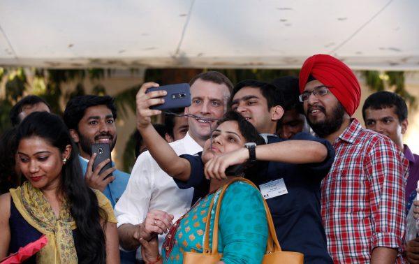 Students take selfies with French President Emmanuel Macron after a meeting in New Delhi, India, March 10, 2018. (Reuters/Adnan Abidi)