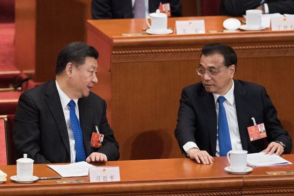 Chinese leader Xi Jinping (L) and Premier Li Keqiang talk with each other as they attend a session of the National People's Congress at the Great Hall of the People in Beijing on March 13, 2018. (Nicolas Asfouri/AFP/Getty Images)
