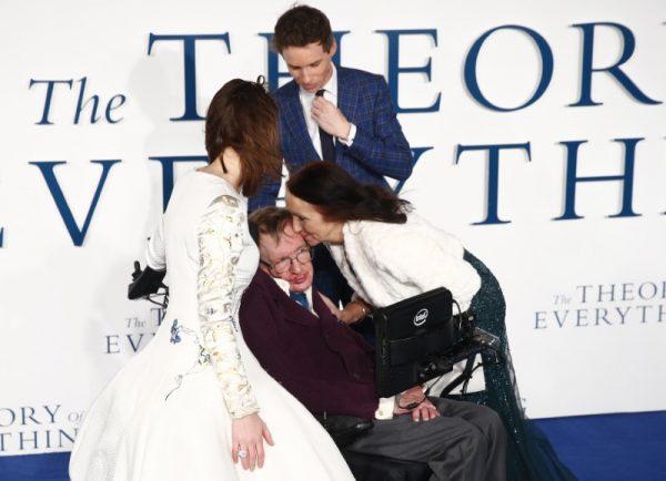 Jane Wilde Hawking kisses her ex-husband Stephen Hawking as she arrives at the UK premiere of the film "The Theory of Everything" which is based around Stephen Hawking's life, at a cinema in central London Dec. 9, 2014. Actors Eddie Redmayne and Felicity Jones, who play Stephen and Jane in the film, look on. (Reuters/Andrew Winning)