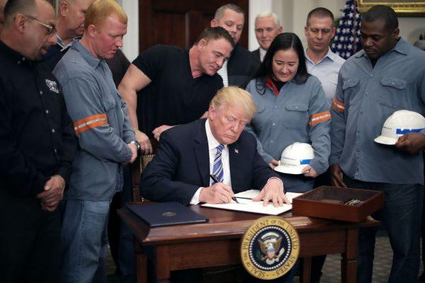  Surrounded by steel and aluminum workers, U.S. President Donald Trump signs a 'Section 232 Proclamation' on steel imports during a ceremony in Roosevelt Room at the White House in Washington on March 8, 2018. (Chip Somodevilla/Getty Images)
