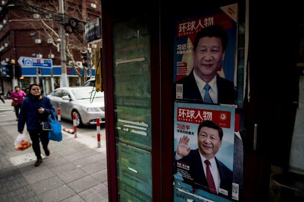 A woman passes a newspaper stand showing a magazine with a picture of Chinese leader Xi Jinping on its cover, in downtown Shanghai on March 12, 2018. (Johannes Eisele/AFP/Getty Images)