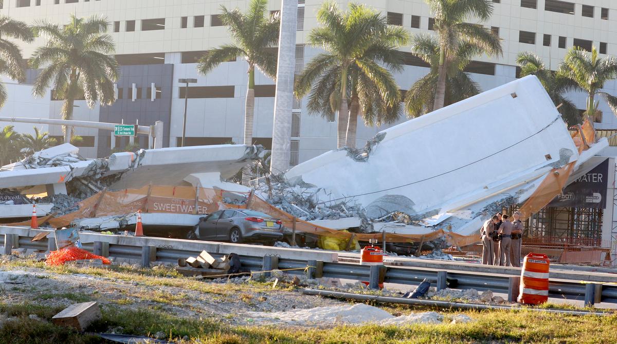 Police officers stand next to a collapsed pedestrian bridge at Florida International University in Miami, Florida, on March 16, 2018. (REUTERS/Joe Skipper)