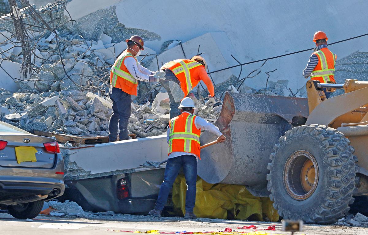 Workers remove debris from a collapsed pedestrian bridge at Florida International University in Miami, on March 16, 2018. (Joe Skipper/Reuters)