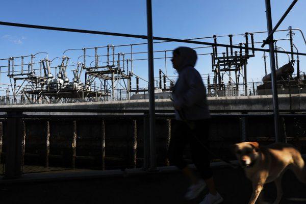 A woman walks by a Con Edison power plant in a Brooklyn neighborhood across from Manhattan on March 15, 2018, in New York City. (Spencer Platt/Getty Images)
