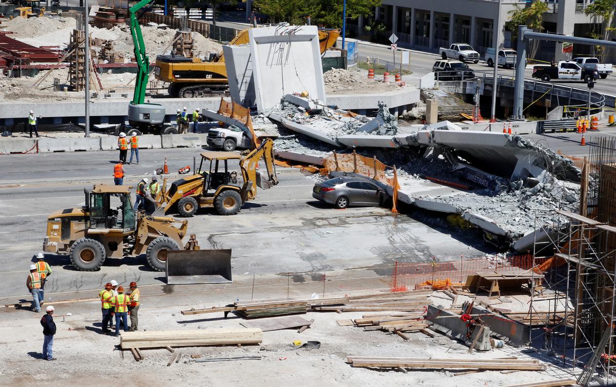 Workers remove debris from a collapsed pedestrian bridge at Florida International University in Miami, Fla., on March 16, 2018. (REUTERS/Joe Skipper)