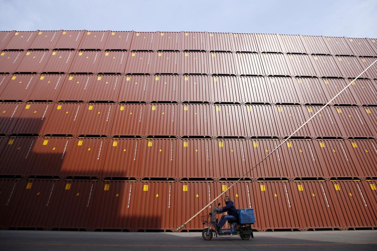 A man rides a vehicle past containers at a port in Shanghai, China, on Feb. 17, 2016. (Aly Song/File Photo/Reuters)
