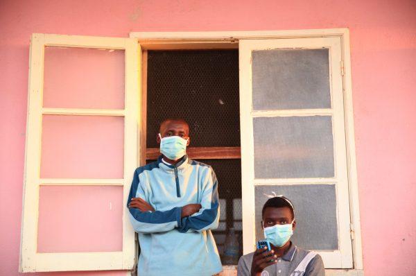 Tuberculosis patients, wearing masks to stop the spread of the disease, stand outside their ward at Chiulo Hospital, Cunene province, Angola February 22, 2018. (Reuters/Stephen Eisenhammer)