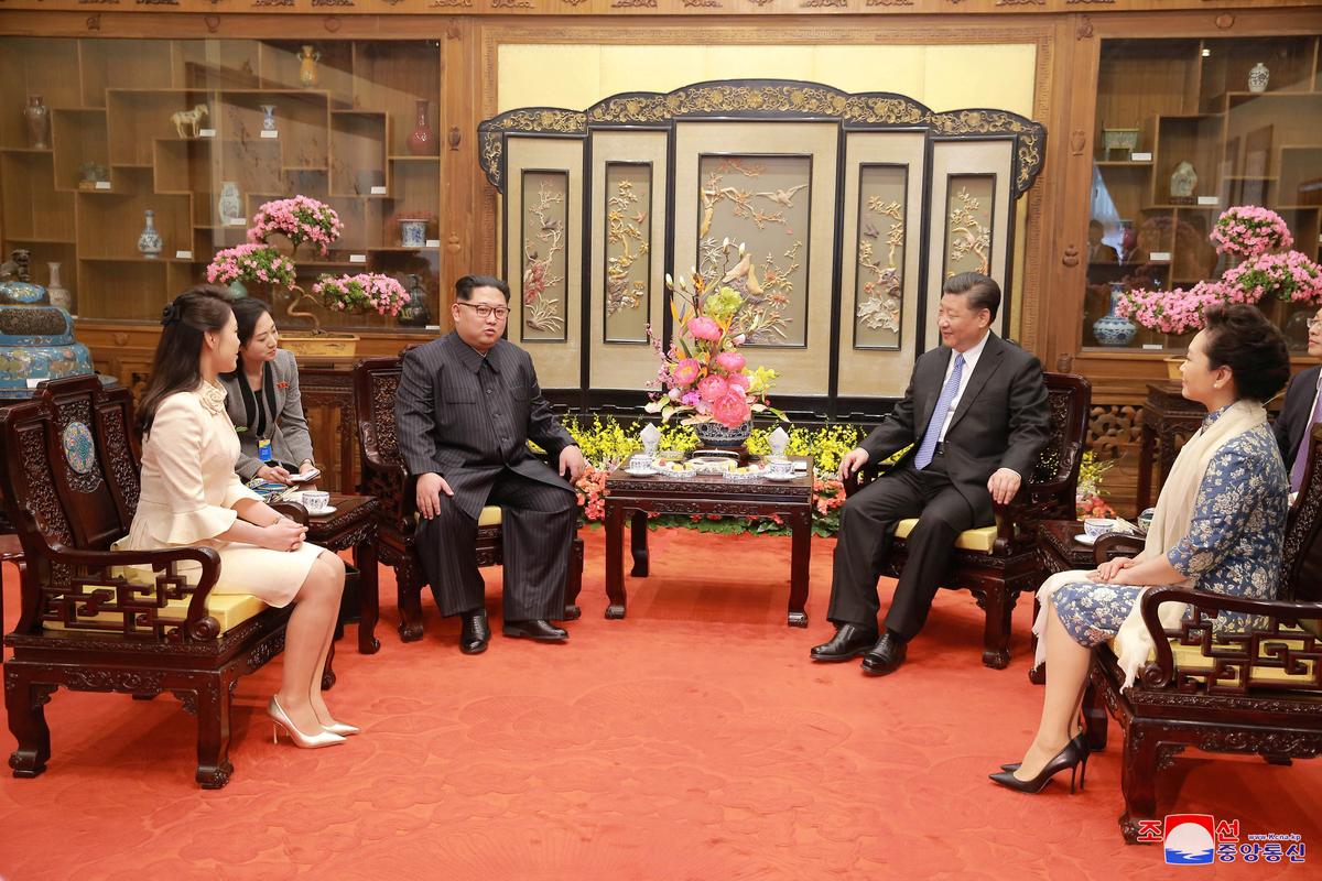 North Korean leader Kim Jong Un and wife Ri Sol Ju, and Chinese leader Xi Jinping and wife Peng Liyuan meet, as Kim Jong Un paid an unofficial visit to Beijing, China, in this undated photo released by North Korea's Korean Central News Agency (KCNA) in Pyongyang, on March 28, 2018. (KCNA/via Reuters)
