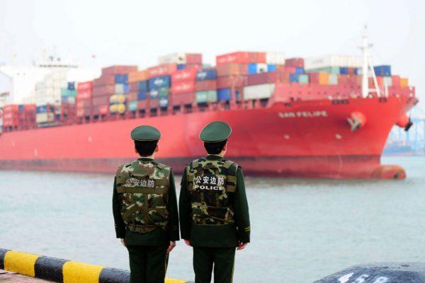 Chinese police officers watch a cargo ship at a port in Qingdao in China's eastern Shandong province on March 8, 2018. (AFP/Getty Images)