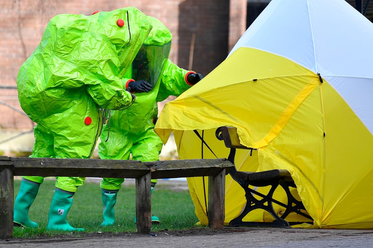 Members of the emergency services in green biohazard encapsulated suits affix the tent over the bench where a man and a woman were found on March 4 in critical condition at The Maltings shopping centre in Salisbury, southern England, on March 8, 2018. (BEN STANSALL/AFP/Getty Images)