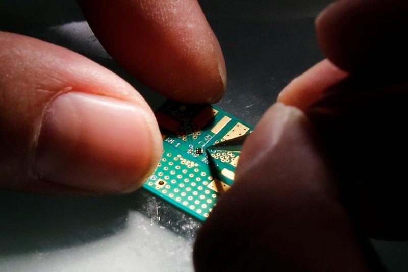 A researcher plants a semiconductor onto an interface board during research to design and develop a semiconductor product, in Beijing, China, on February 29, 2016. (Kim Kyung-Hoon/Reuters)