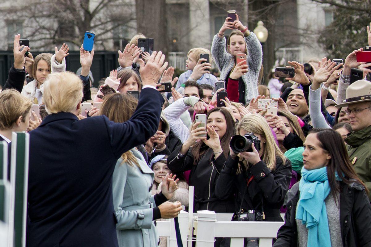 President Donald Trump waves to people at the annual Easter Egg Roll on the South Lawn of the White House on April 2, 2018. (Samira Bouaou/The Epoch Times)